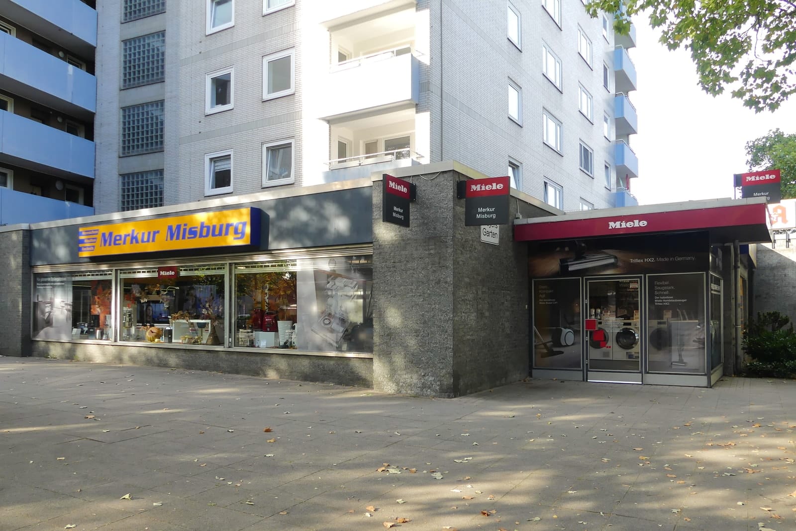 Gesamtansicht des Geschäfts mit Schaufenstern und dem roten Miele-Vordach am Eingang